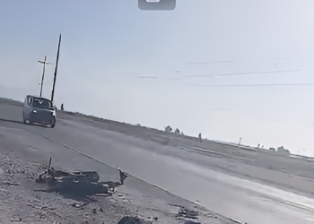 Un  joven en su moto por la avenida.